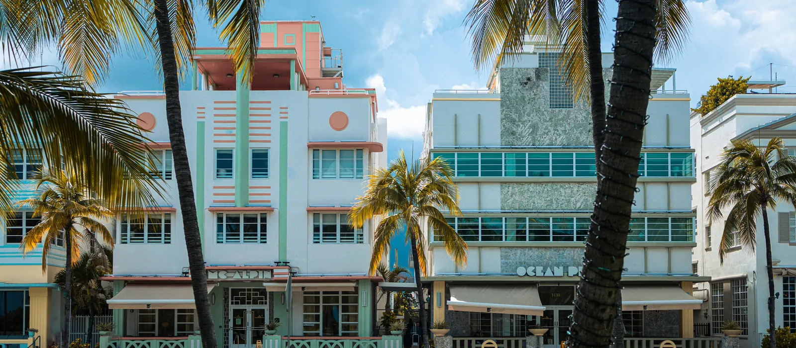 Pastel Art Deco buildings framed by palm trees on Ocean Drive